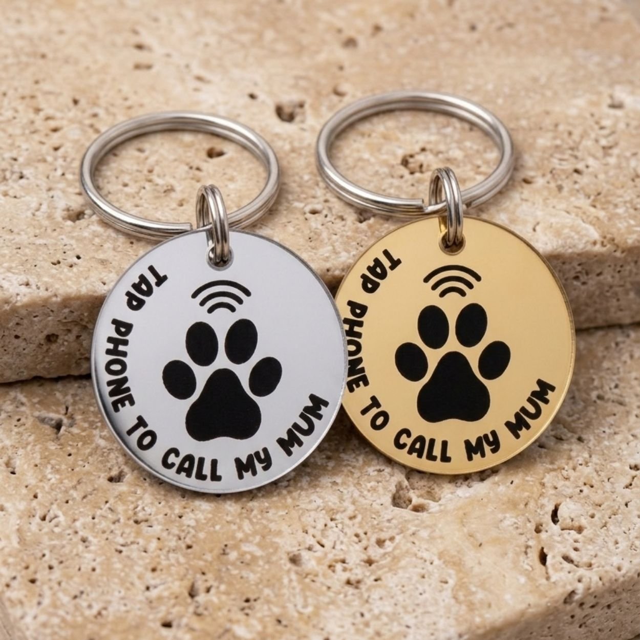 Silver and gold NFC pet tags on a stone surface