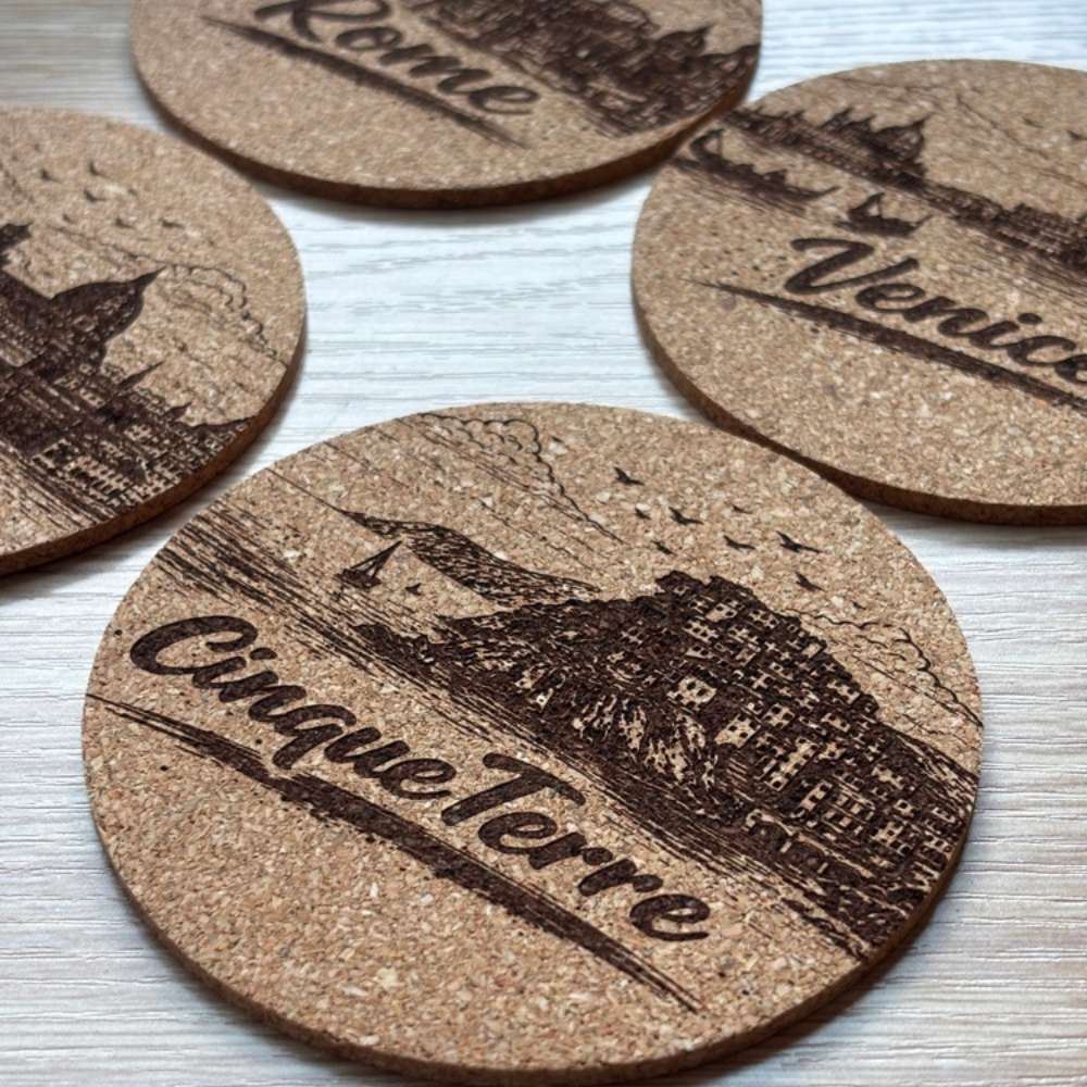 Four natural cork coasters with engraved European city illustrations, perfect for Italian travel lovers and home décor